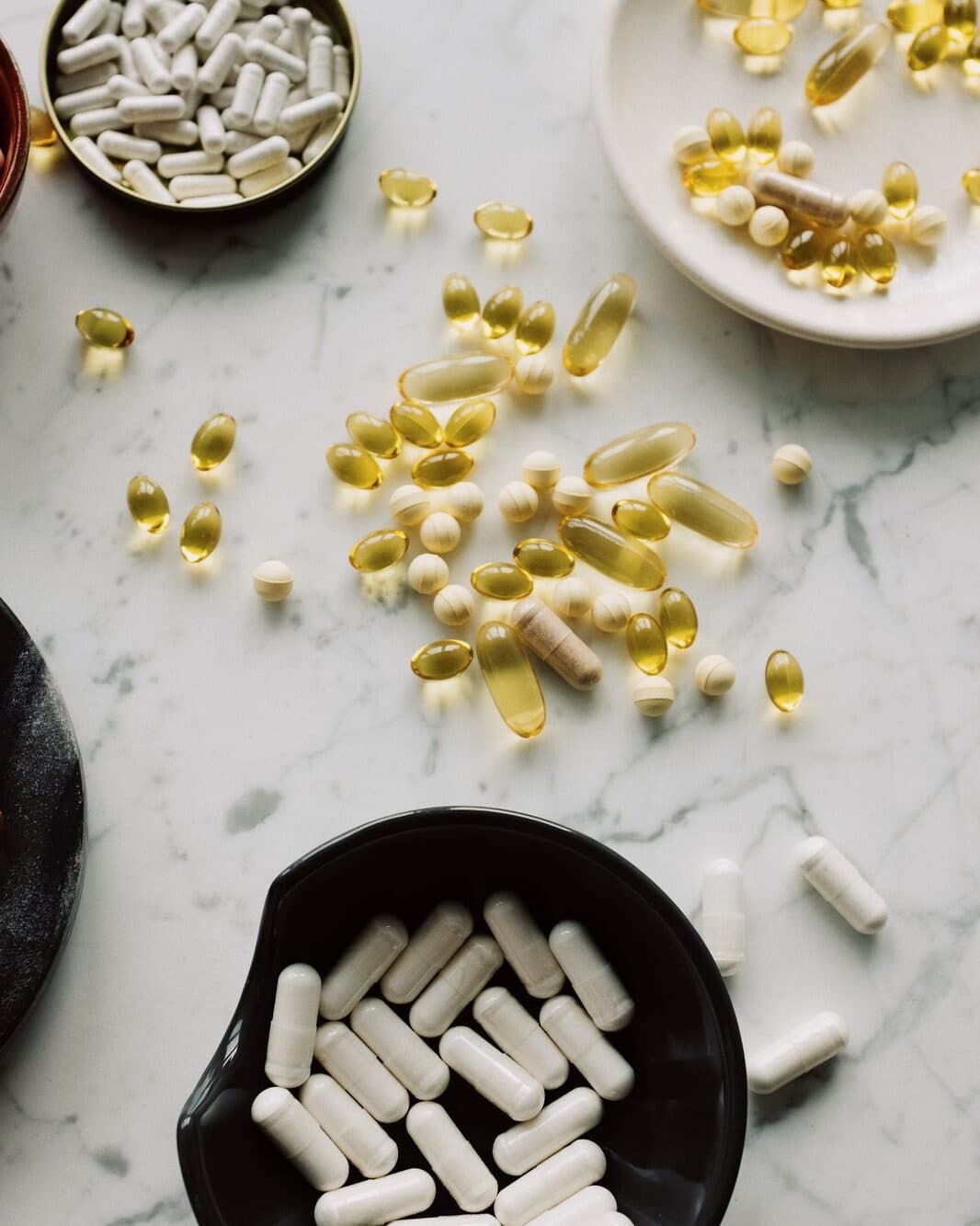 Thoughtfully formulated supplement capsules and softgels on marble